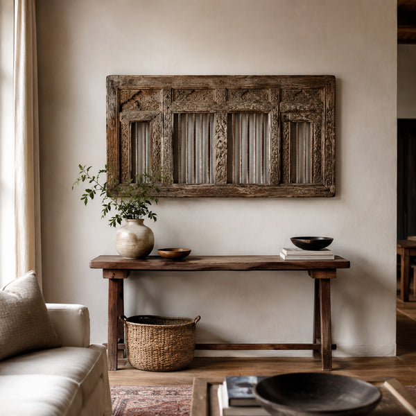 Antique carved wooden architectural panel displayed above a console